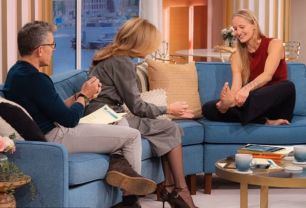 A group of women practicing quadrobics and primal movement exercises together in an outdoor park setting.