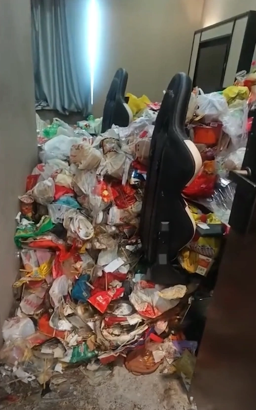  Professional cleaners in protective gear clearing massive trash from a hotel room.