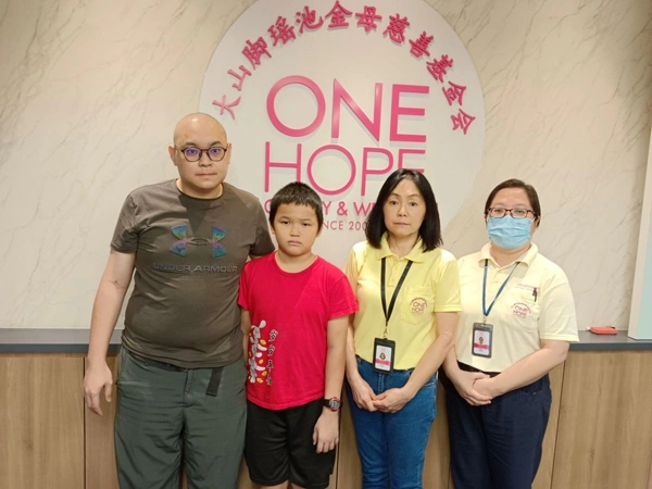 Young boy in hospital gown preparing for bone marrow donation surgery to save his father.