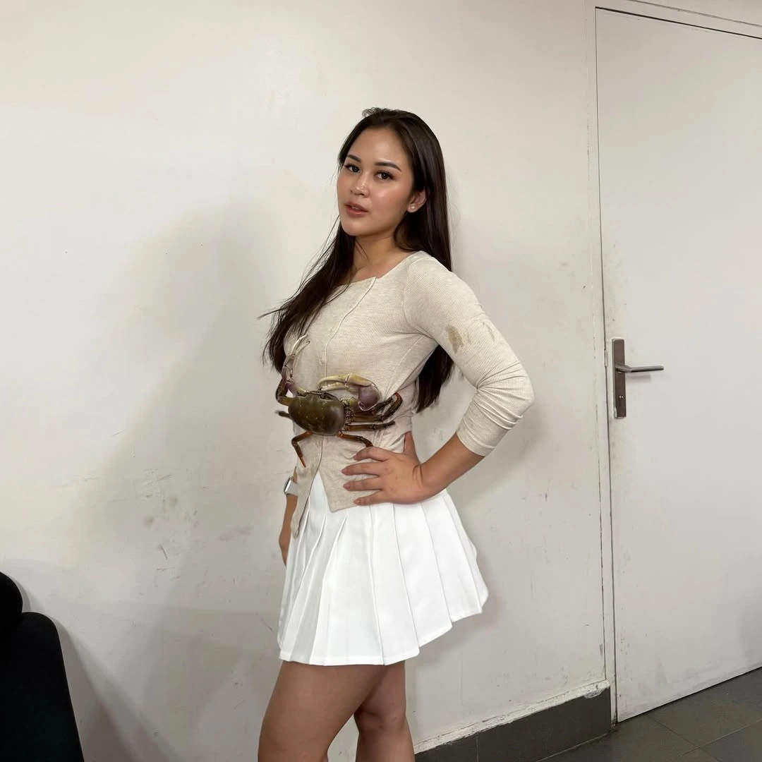 James the pet crab enjoying a gourmet meal hand-fed by his Indonesian owner.