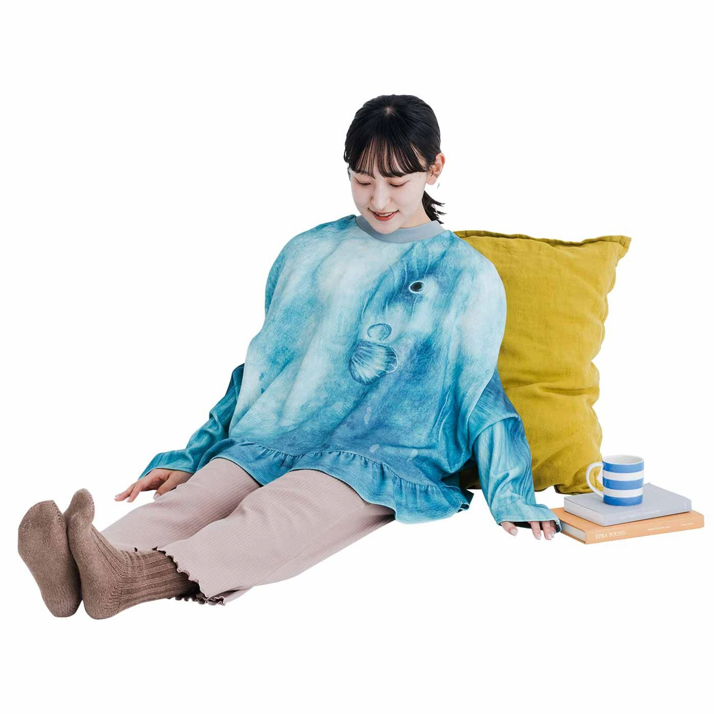 A model wearing the giant, grey knitted Ocean Sunfish (Mola Mola) sweater from Japan, with arms extended into the fins to show its unique shape and face design.