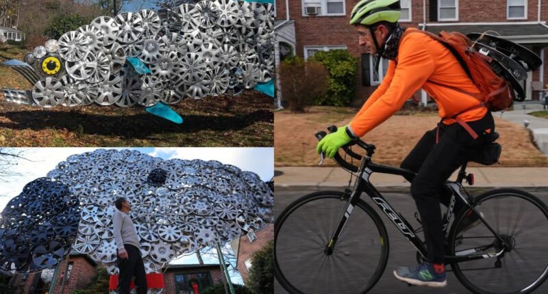 A long public fence decorated with dozens of recycled hubcaps creating a reflective art piece.