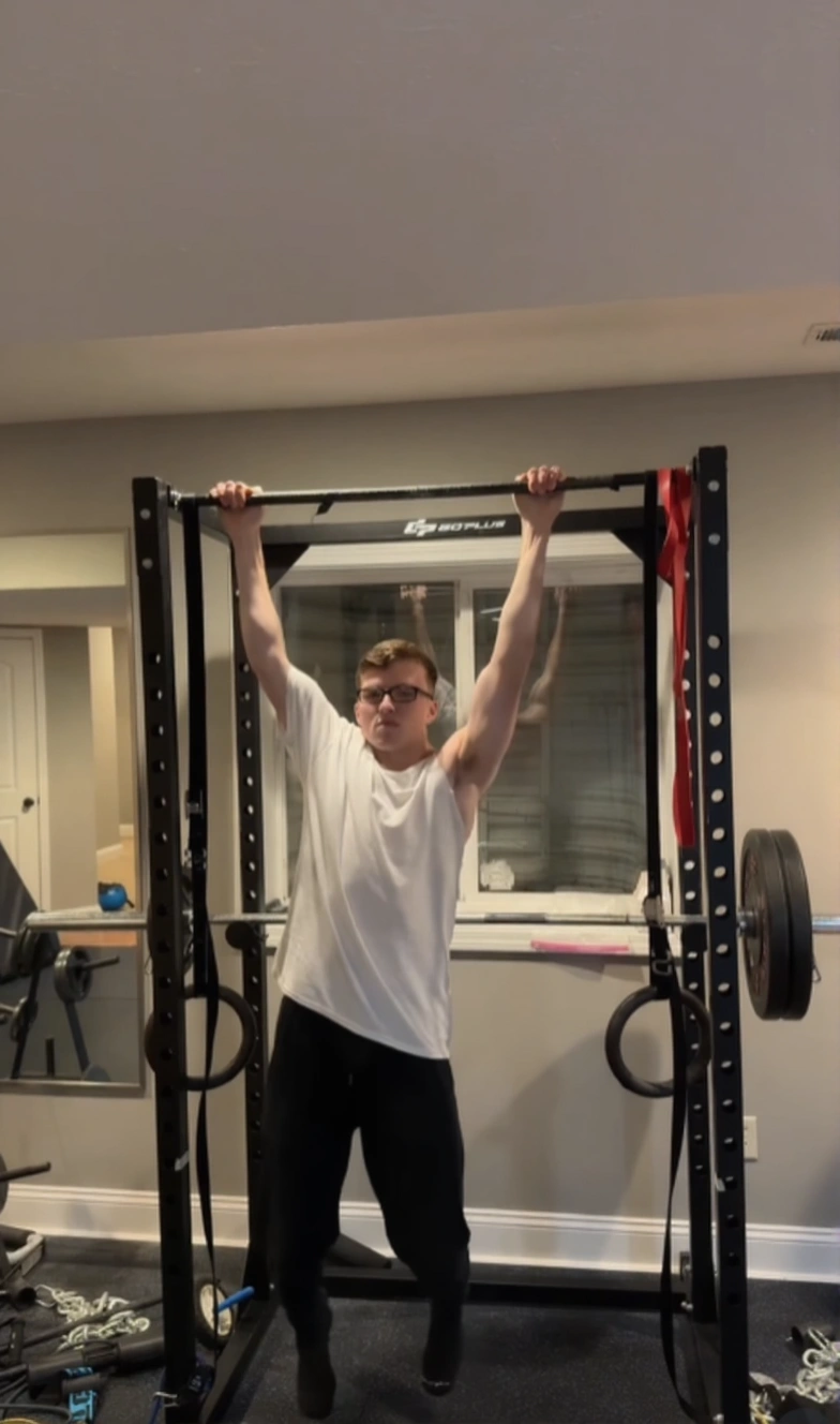 Rear view of a man showing one-sided trap development from 200 days of training.